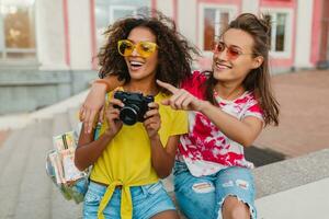 feliz jovem meninas amigos sorridente sentado dentro rua foto