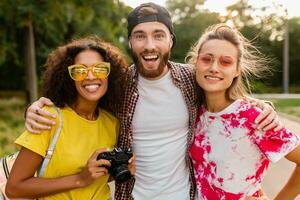 feliz jovem companhia do emocional sorridente amigos caminhando dentro parque foto