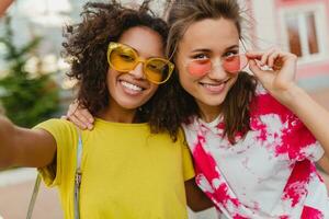 feliz jovem meninas amigos sorridente sentado dentro rua foto