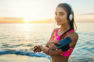 jovem mulher fazendo esporte exercícios em nascer do sol de praia dentro manhã foto