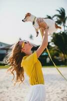 jovem à moda hipster mulher segurando caminhando jogando cachorro foto