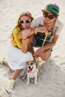 jovem à moda hipster casal dentro amor jogando cachorro foto