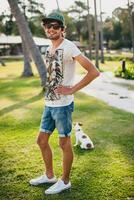jovem à moda hipster homem caminhando jogando cachorro cachorro jack russell foto