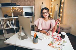 mulher dentro Rosa luxo vestir, verão tendência, moda desenhador trabalhando às escritório em computador foto