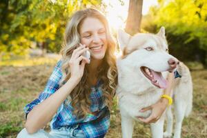 mulher com cachorro falando em telefone foto