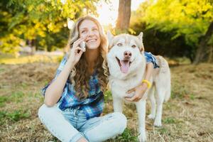 mulher com cachorro falando em telefone foto