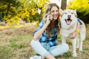 mulher com cachorro falando em telefone foto