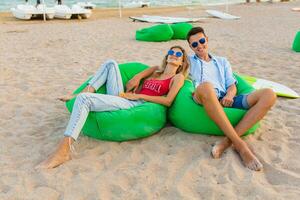 jovem sorridente casal tendo Diversão em de praia relaxante foto