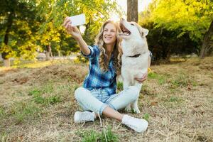 fofa jovem à moda bonita sorridente feliz loiro mulher jogando com cachorro foto