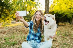 fofa jovem à moda bonita sorridente feliz loiro mulher jogando com cachorro foto