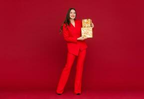 atraente mulher a comemorar Natal em vermelho fundo foto