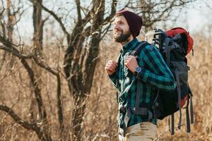 jovem hipster homem viajando com mochila dentro Primavera outono floresta foto