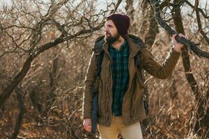 jovem hipster homem viajando com mochila dentro Primavera outono floresta foto