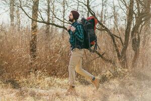 jovem hipster homem viajando com mochila dentro Primavera outono floresta foto