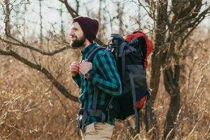 jovem hipster homem viajando com mochila dentro Primavera outono floresta foto