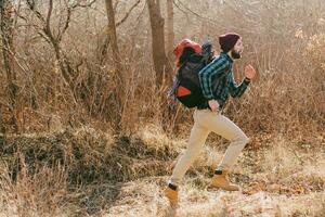 jovem hipster homem viajando com mochila dentro Primavera outono floresta foto