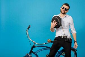 jovem bonito sorridente feliz homem viajando em hipster bicicleta foto