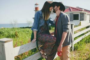 rindo jovem hipster casal indie estilo dentro amor caminhando dentro campo foto