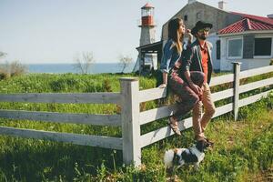 jovem à moda hipster casal dentro amor caminhando com cachorro dentro interior, tendo Diversão foto