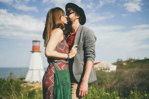 sorridente segurando mãos jovem hipster casal indie estilo dentro amor caminhando dentro campo foto