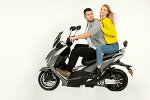 jovem atraente casal equitação a elétrico moto lambreta feliz tendo Diversão juntos foto