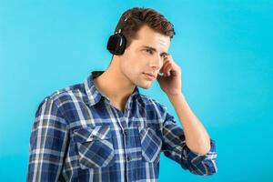 à moda jovem homem ouvindo para música em sem fio fones de ouvido foto