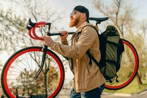 bonito barbudo homem viajando com bicicleta dentro manhã foto