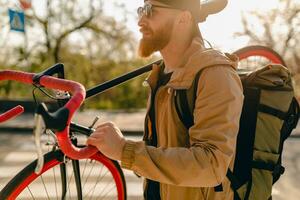 bonito barbudo homem viajando com bicicleta dentro manhã foto