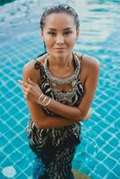 jovem ásia sexy lindo mulher dentro tropical vestir, zebra imprimir, posando dentro piscina foto