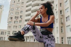 atraente Preto africano americano mulher dentro esporte ginástica equipamento em telhado fazer trabalhos Fora foto