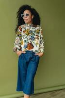 atraente Preto africano americano mulher dentro à moda equipamento em verde estúdio fundo foto