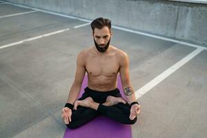 atraente hansome homem com Atlético Forte corpo fazendo manhã ioga dzen meditação foto