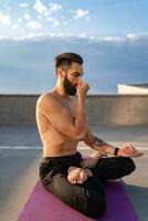 atraente hansome homem com Atlético Forte corpo fazendo manhã ioga dzen meditação foto