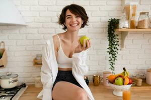 jovem bonita mulher cozinhando às lar, manhã cozinha, saudável Comida foto