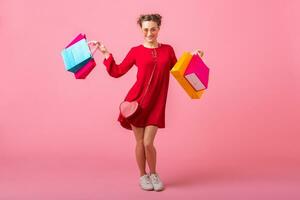 atraente feliz sorridente à moda mulher segurando compras bolsas foto