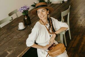 lindo mulher sentado dentro cafeteria em período de férias vestido dentro branco verão moda vestir foto