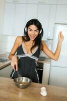 atraente sorridente mulher dentro pijamas tendo café da manhã dentro cozinha foto