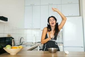 atraente sorridente mulher dentro pijamas tendo café da manhã dentro cozinha foto