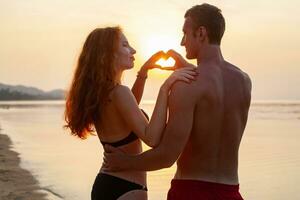 jovem sexy romântico casal dentro amor feliz em verão de praia juntos tendo Diversão vestindo nadar ternos foto