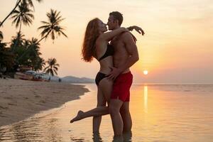 jovem sexy romântico casal dentro amor feliz em verão de praia juntos tendo Diversão vestindo nadar ternos foto