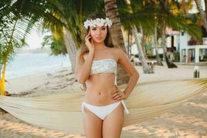 jovem sexy mulher dentro branco bikini roupa de banho em tropical de praia foto