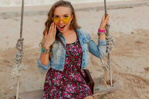 à moda mulher dentro verão vestir período de férias em de praia dentro colorida amarelo óculos de sol sorridente feliz foto