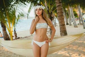 jovem sexy mulher dentro branco bikini roupa de banho em tropical de praia foto