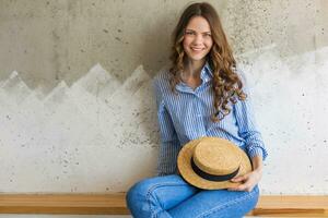 retrato do jovem bonita mulher com Palha chapéu jeans azul algodão camisa foto