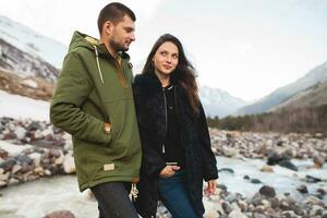 jovem lindo hipster casal caminhada dentro montanhas foto