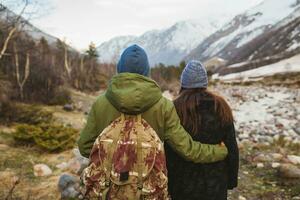 jovem lindo hipster casal caminhada dentro montanhas foto