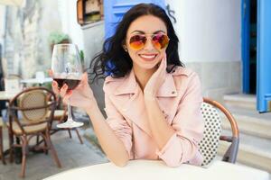 atraente jovem mulher bebendo vinho foto