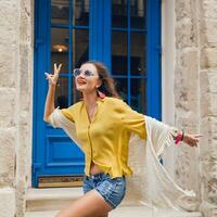 jovem lindo à moda mulher caminhando dentro velho cidade rua foto