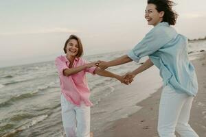 dois jovem mulheres tendo Diversão em a de praia foto