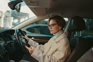 atraente à moda mulher sentado dentro carro vestido dentro casaco foto